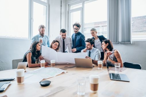 Versicheralles team analysiert gemeinsam Versicherungen und Finanzplanung am Tisch